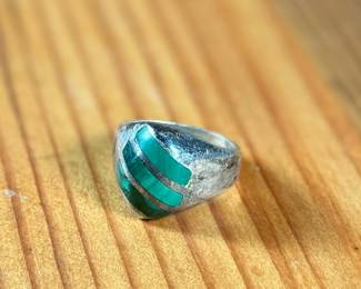 This lot features a sterling silver ring with Malachite inlay in a size 10.5 with a total approx. weight of 16.37 grams.