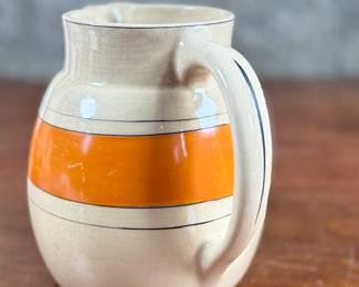This lot features an early banded pitcher by Roseville Pottery circa 1920s or 1930s. The pitcher is in good condition and measures, 6.25” H x 7.5” W x 5.5” D.