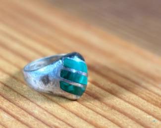 This lot features a sterling silver ring with Malachite inlay in a size 10.5 with a total approx. weight of 16.37 grams.