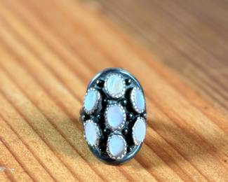 This lot features a beautiful sterling silver ring with what appears to have mother of pearl inlay. Signed, “touchine” and comes in a size 7.