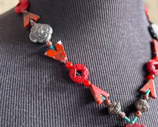 This lot features a beautiful necklace with sterling silver and what appears to be carved coral and turquoise. This necklace is in excellent condition and measures, 22”.