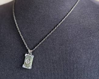 This lot features a stunning sterling silver necklace with a silver pendant wrapped around a jade stone. Measures, 20” and has a total approx. weight of 12.80 grams.