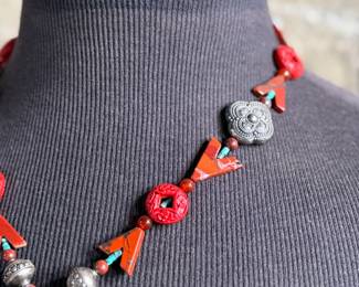 This lot features a beautiful necklace with sterling silver and what appears to be carved coral and turquoise. This necklace is in excellent condition and measures, 22”.