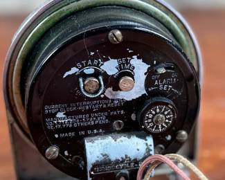 Hammond Instrument Company electric clock, made in the USA, featuring a chrome and black casing with a tan clock face and black numerals. The item includes original wiring and a two-prong plug. The back carries instructions for use and patent information. Tested and in working condition.