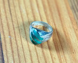 This lot features a sterling silver ring with Malachite inlay in a size 10.5 with a total approx. weight of 16.37 grams.