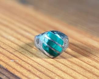 This lot features a sterling silver ring with Malachite inlay in a size 10.5 with a total approx. weight of 16.37 grams.