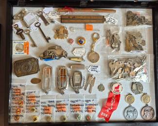 Hood ornaments, keys, belt buckles, pin backs, Bill Clinton tax refund.