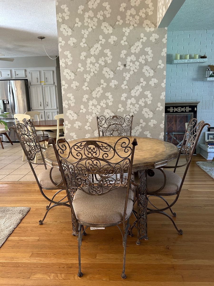Mediterranean inspired wrought iron dining set pieces, featuring intricate scrolled designs and upholstered seats