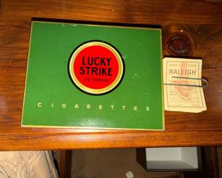 vintage green Lucky Strike cigarette tin is a collectible "Flat Fifties" container from approximately the 1930s or 1940S along with Raleigh Cigarette Coupons. Tin is empty