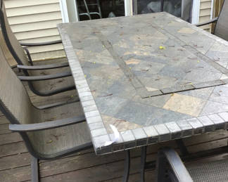 Lot 74: Outdoor tiled dining table with six metal-framed mesh chairs