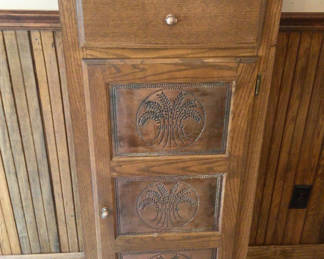 Lot 16: Oak tall cabinet with three carved palm-tree panels