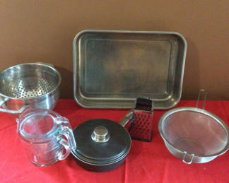 Lot 25: Assorted kitchenware set: steamer basket, baking tray, grater, pot with lid, colander, and measuring pitcher