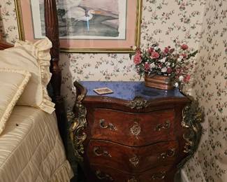 French Louis XV style bombe commode featuring a marble top, marquetry inlay, and ornate brass ormolu mounts.
