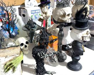 Halloween decor including skulls, spiders, trees, decanter, orbs, pillows, placemats, dish towels