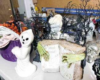 Halloween decor including skulls, spiders, trees, decanter, orbs, pillows, placemats, dish towels