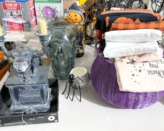Halloween decor including skulls, spiders, trees, decanter, orbs, pillows, placemats, dish towels