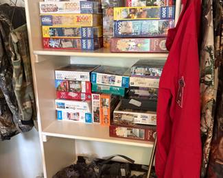 Bedroom closet- men’s hunting bottom - puzzles in top of closet & to left are hunting clothes