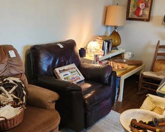 Leather? Recliner, mauve fabric recliner, MCM nesting tables, coffee table books, cookbooks, vintage collectible miniature train set, wooden carved spoons and ladies, dough bowls, vintage amber glass lamp