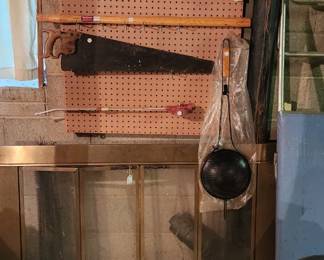 Vintage dart board, bb gun, sledge hammer handle, new fireplace popcorn popper, antique one man crosscut saw, vintage handsaw, brass trim fireplace screen