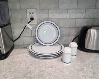 🍽️ Classic White Dinnerware Set with Blue Trim 🍽️  Clean and timeless dinnerware set featuring elegant white ceramic pieces with subtle blue trim detailing. Includes plates, bowls, and matching salt and pepper shakers. Perfect for everyday dining, guest settings, or cottage-style kitchen décor.  ✨ Classic white finish with blue accent trim ✨ Includes plates, bowls & matching shakers ✨ Simple, clean, and versatile design ✨ Great for everyday use or display ✨ Good overall condition  A charming and practical addition to any kitchen or dining collection.