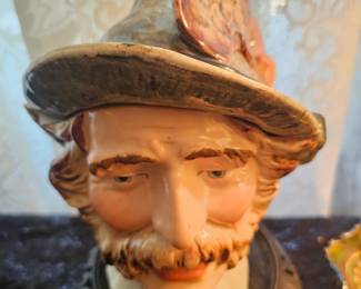 A majolica figural tobacco jar depicting a man in a feathered hat.