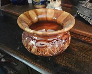 A brown glazed ceramic cuspidor with a morning glory relief decoration.
