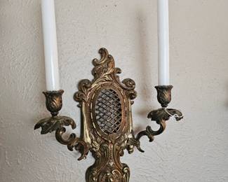 Ornate brass two-light wall sconce with scrollwork and mesh detail.