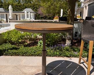JANUS Et Cie Teak Bistro Table With Power Coated Steel Base - 2 Available. Measures 36" D x 42" H. The Tables Are In Great Condition. No Bistro Chairs.  Photo 1 of 2. 