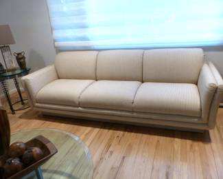 Neutral modern sofa, small side table, lamp