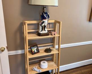 4-tier slatted bookcase with decorative items and Napolean Bonaparte lamp