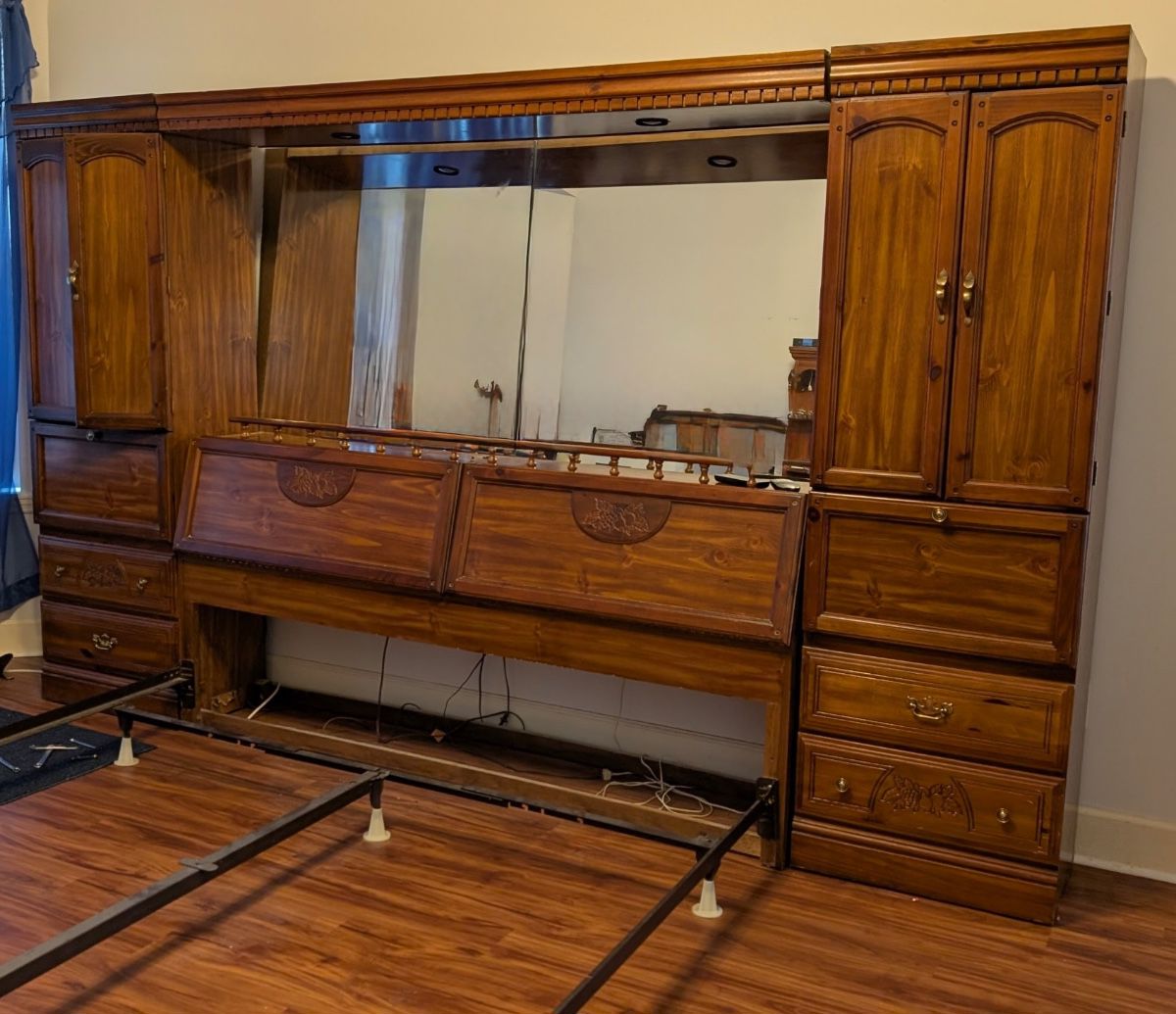 King size, armoire on each side. Headboard opens for storage. Mirror with lights above.