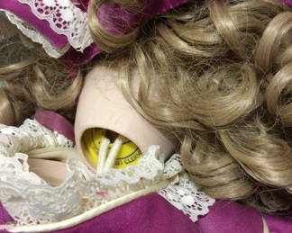 Lot 493: Blonde doll in pink dress and a wicker doll carriage with a second doll