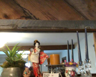 Lot 34: Decorative shelf arrangement with plants, a kimono-doll figurine, candles, and floral ceramics