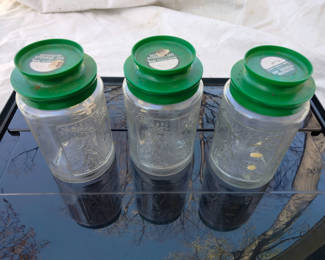 Lot 12: Three Glass Storage Jars with Green Lids