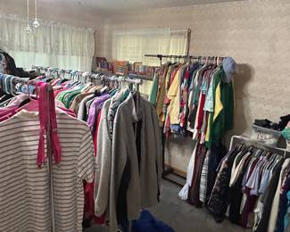 Large bedroom full of clothes, shoes and purses