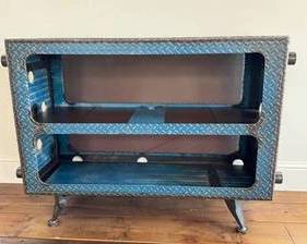 Artisan Steel Bookcase - Industrial Diamond-Plate  This artisan-crafted steel bookcase blends rugged industrial styling with practical storage. The blue diamond-plate exterior is built for durability, featuring welded seams and heavy-gauge construction. It measures approximately 49 in W x 39 in H x 37 in D and provides two open shelves above a lower storage area, crafted from sturdy metal surfaces. Ideal for industrial lofts, studios, or workshop spaces, this unit makes a bold storage statement. Looks to be created by artist Cindy Wynn, however; no signature was found and this piece is too heavy to turn upside down to check!   Dimensions: 49 in W x 39 in H x 37 in D Material/Finish: Steel with blue diamond-plate exterior finish Shelving: Two open shelves above a lower storage compartment Legs/Support: Four adjustable leveling feet for stability Weight/Build: Very heavy, solid-metal construction Condition: Excellent condition