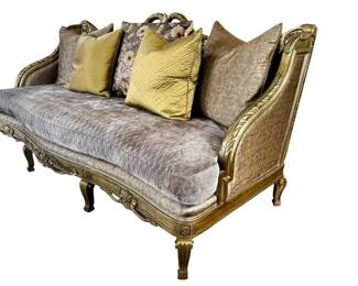 Custom Sofa - Luxurious Fabric, Gold Carved Frame  This custom sofa combines a plush, luxurious fabric with an ornate giltwood frame to create a regal centerpiece for formal living spaces. The carved gold-tone frame features scrolling leaves and floral motifs that echo traditional luxury. Measuring about 100 in long, 41 in deep, and 48 in high, it anchors a room with presence. A five-piece pillow set in coordinating gold and damask patterns adds texture and color to the arrangement.
