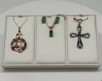 Gold and gemstone pendant necklaces, a necklace and earrings set, and a gem-set pendant cross necklace