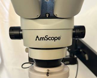A closeup of the AmScope stereo zoom microscope on an articulating arm stand