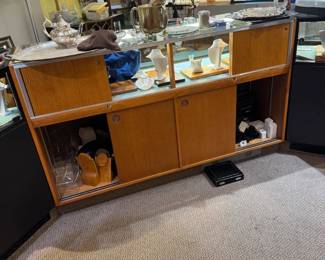 Back view of one of a pair of 5-1/2’ showcases with storage cabinets with sliding doors