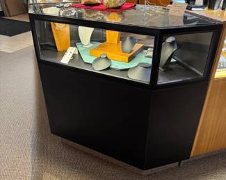 One of a total of four lighted locking corner showcases in black Formica, front view