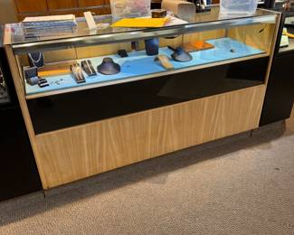 One of a pair of 5-1/2’ showcases fitted with multiple storage drawers
