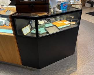 One of a total of four lighted locking corner showcases in black Formica, front view