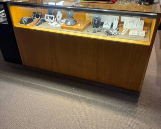 One of a pair of 5-1/2’ showcases fitted with multiple storage drawers