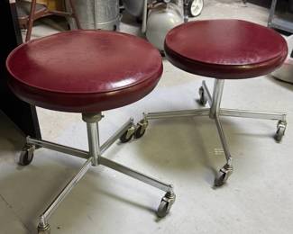 Pair of mid-century industrial Naugahyde covered wheeled stools