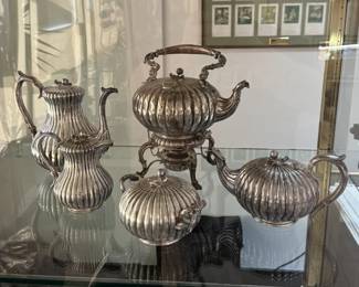A rare circa 1850s antique coin silver coffee and tea service in charming ribbed melon form design, composed of a coffee pot, teapot, hot water kettle on stand with burner, a lidded creamer, and lidded sugar. Each finial is in the shape of a stem, leaf and fruit, while the handles on the sugar bowl are in branch/stem form. Stamped on the base with "Boston", "Jones, Ball & Co" and "Pure Coin"