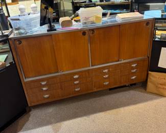 Back view of one of a pair of 5-1/2’ showcases fitted with multiple storage drawers