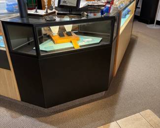 One of a total of four lighted locking corner showcases in black Formica, front view