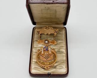 A gold-filled 1904 Muskegon Masonic Past Master badge pin featuring a compass, square, and quadrant design, in original leather presentation box.  Inscribed on the back with "Presented by Lovell Moore Lodge to Geo. H. Armstrong January 4th 1904"