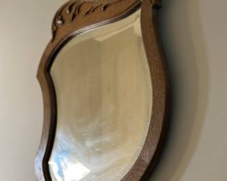 Shield-shaped, light walnut, carved wood mirror from the 1940s
